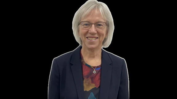 A portrait of a woman wearing a suit against a black background. 