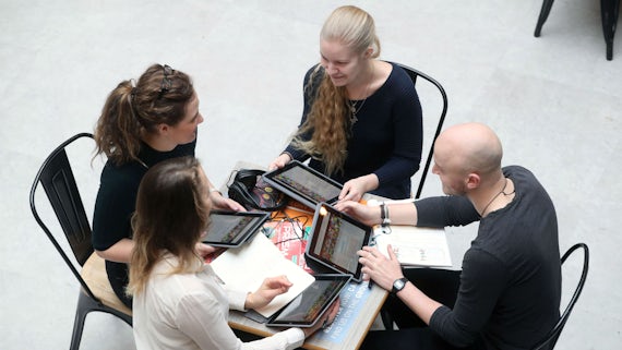 Students with ipads sitting around a table seen from above