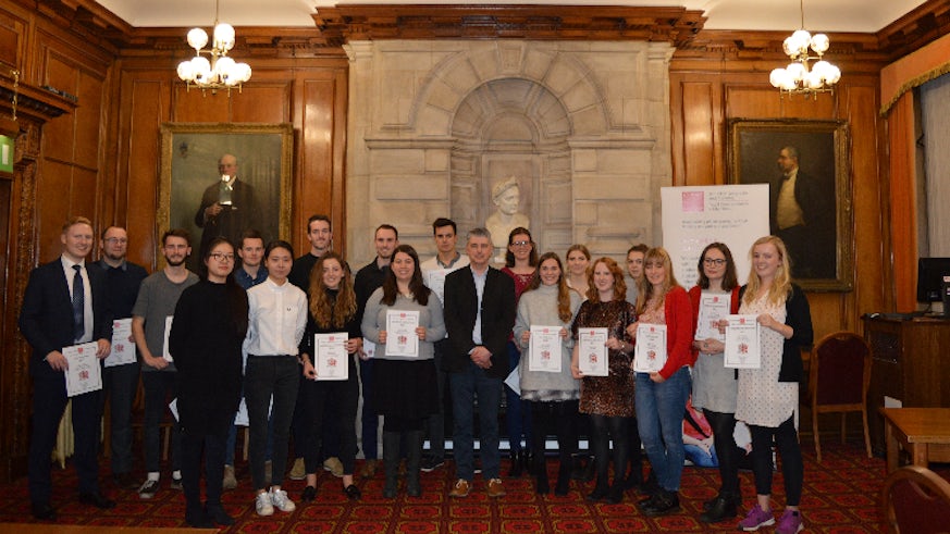 Image shows large group of undergraduate and postgraduate students holding certificates alongside the Head of the School of Geography and Planning