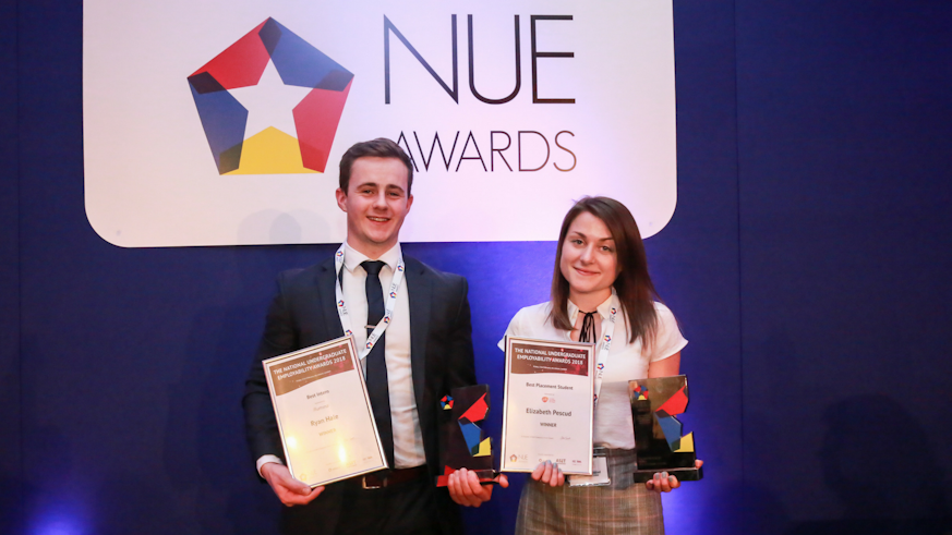 Two students holding awards