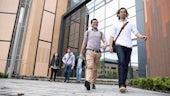 Two male PG students walking out of a building