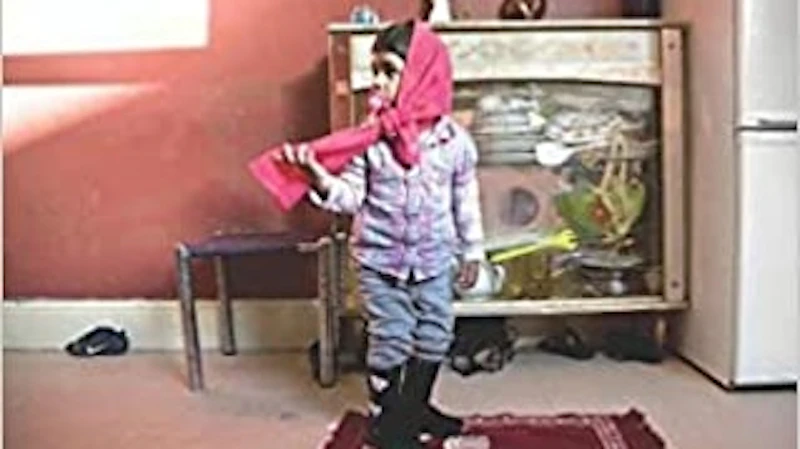 Muslim child in a front room