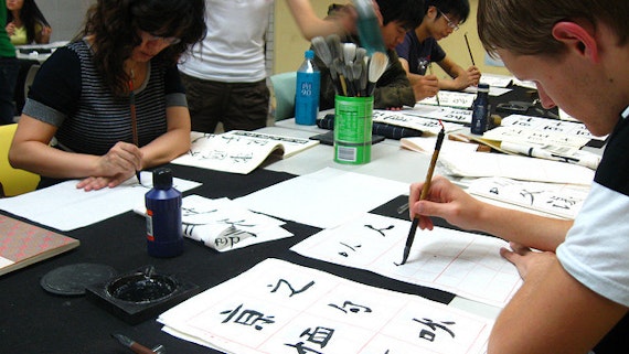Students practice calligraphy