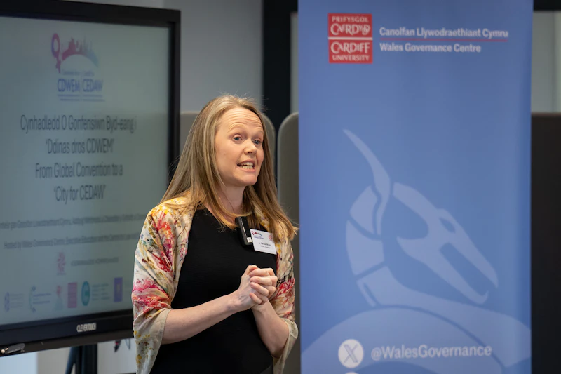 Mid shot of woman speaking at conference.