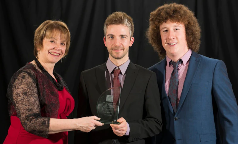 Image of Jayne Dowden presenting the Professional Services Team of the Year award to Daniel John and Owen Thomas, from Cardiff Business School, at the 2016 Celebrating Excellence Awards