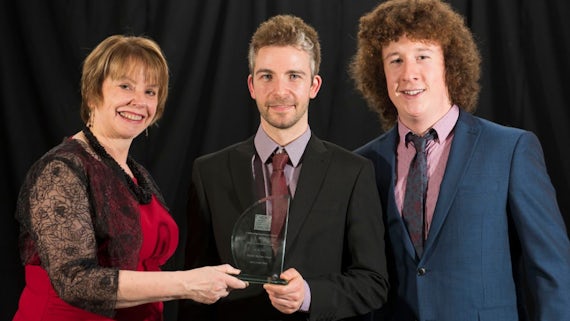 Image of Jayne Dowden presenting the Professional Services Team of the Year award to Daniel John and Owen Thomas, from Cardiff Business School, at the 2016 Celebrating Excellence Awards