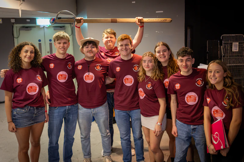 A group of male and female students are smiling at the camera.