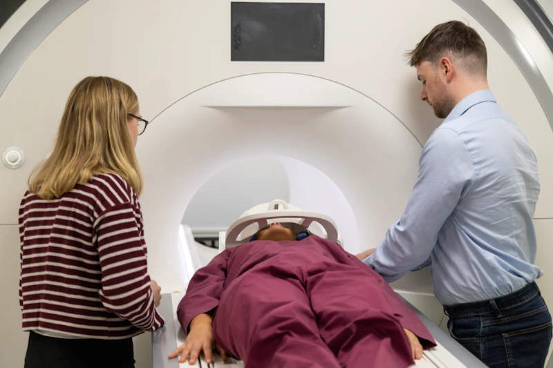 A rugby athlete enters the MRI scanner under the supervision of two researchers