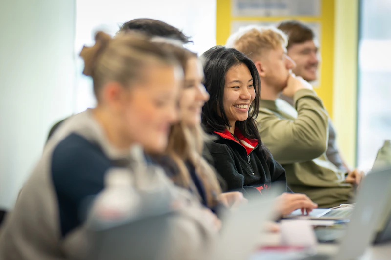A group of students, focus on one smiling girl.