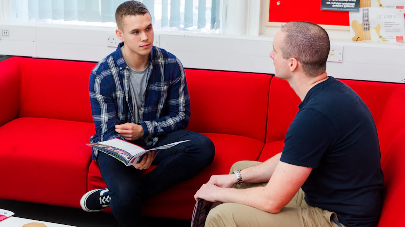 A student and member of staff chatting.